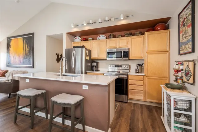 a kitchen with stainless steel appliances granite countertop a stove a sink and a refrigerator