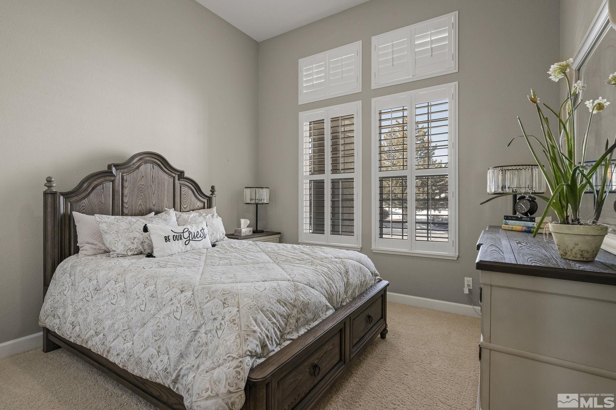 6982 Peacepipe Court Reno, NV 89511 - Photo 17 of 28 a bedroom with a large bed and a potted plant