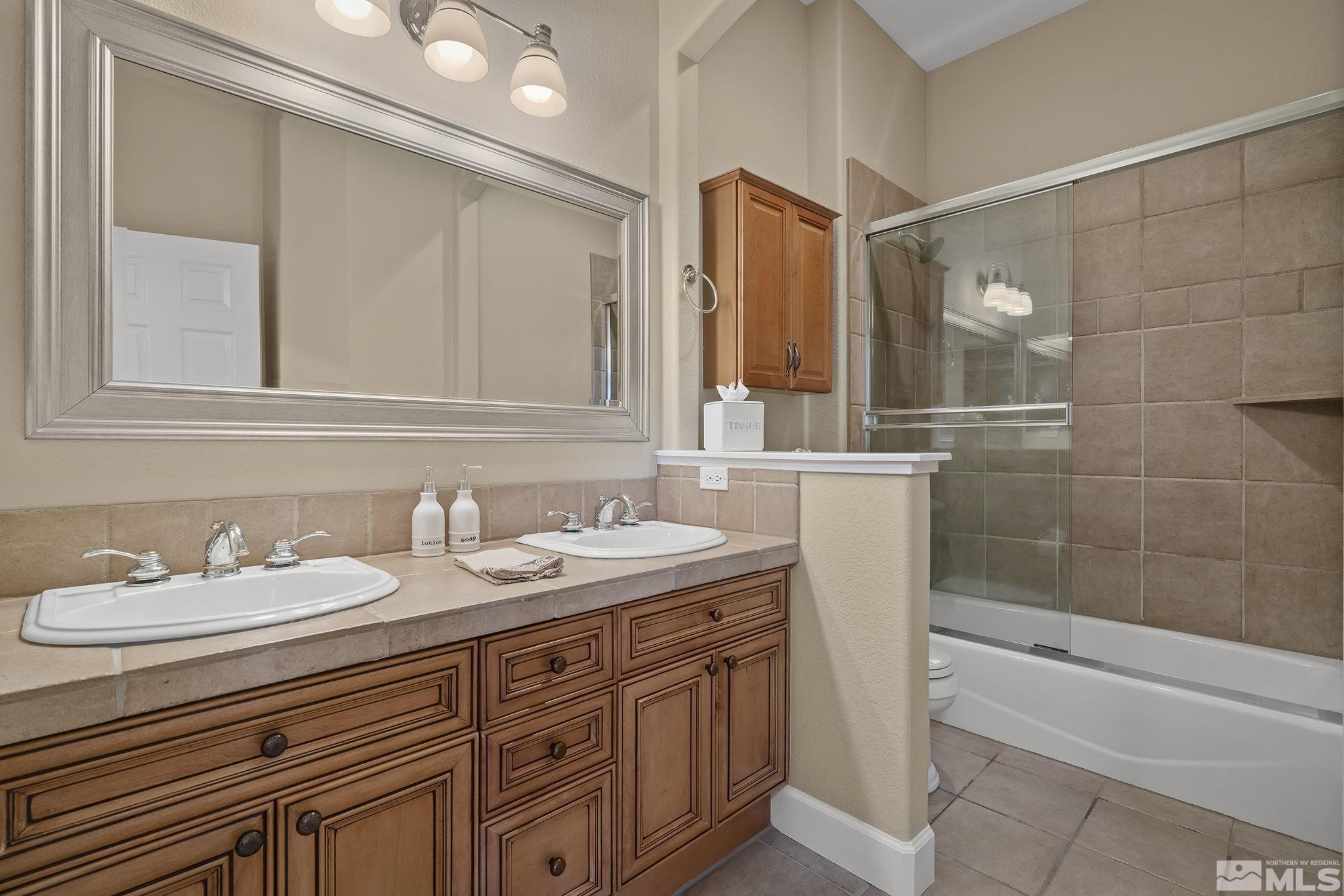 6982 Peacepipe Court Reno, NV 89511 - Photo 18 of 28 a bathroom with a granite countertop sink mirror and double