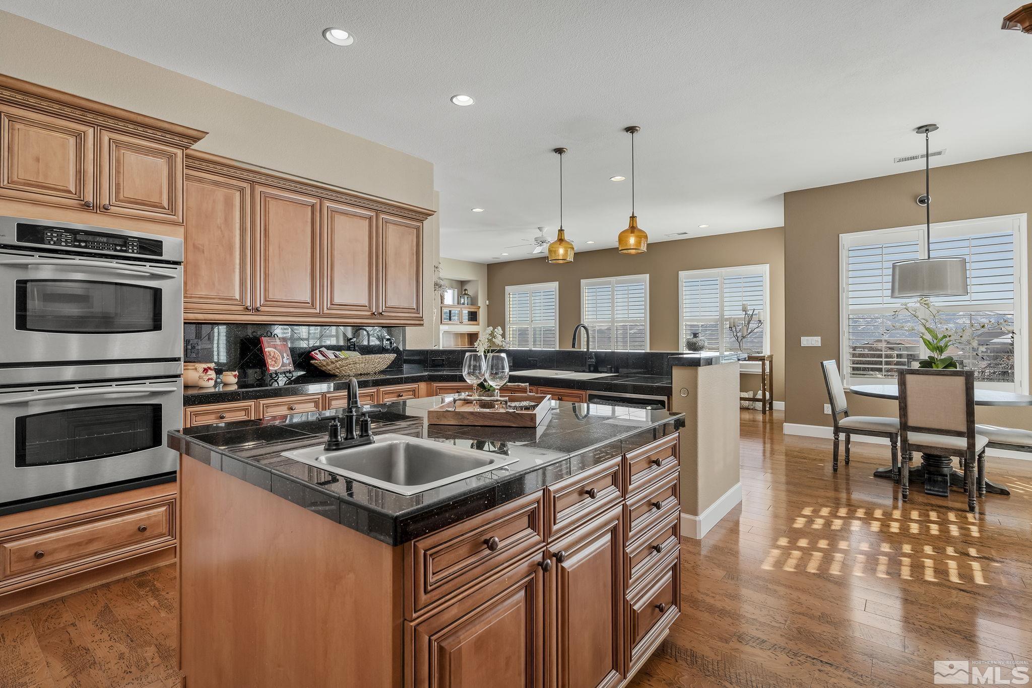 6982 Peacepipe Court Reno, NV 89511 - Photo 6 of 28 a kitchen with stainless steel appliances granite countertop a stove a sink and a microwave