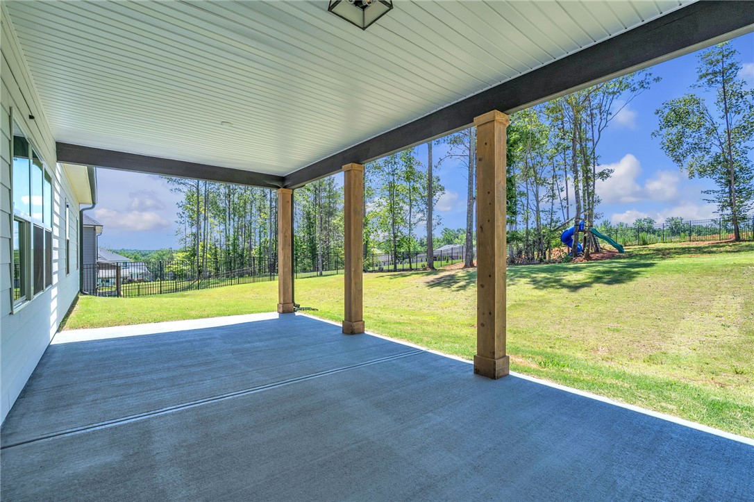 226 Holly Br Road Piedmont, SC 29673 - Photo 36 of 44 An inviting covered patio offers ample space for outdoor enjoyment, overlooking a serene fenced yard.