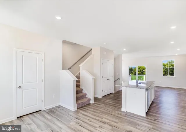 a view of a livingroom with wooden floor and stairs