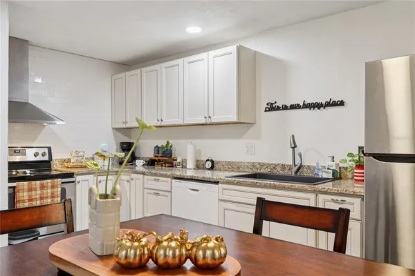 a kitchen with stainless steel appliances granite countertop a sink and cabinets