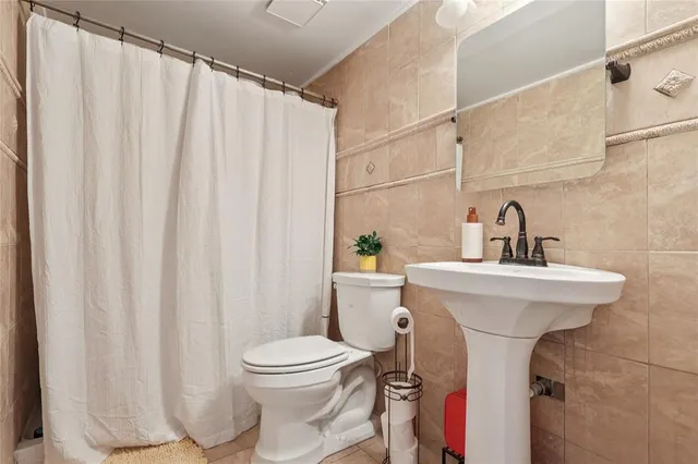 a bathroom with a sink a toilet and a mirror