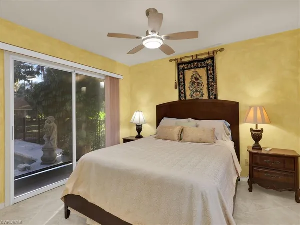 a bedroom with a large bed and a chandelier fan