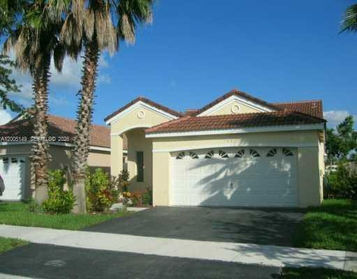 519 Talavera Road Weston, FL 33326 - Photo 1 of 19 a front view of a house with garden