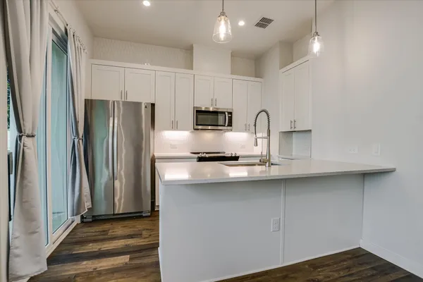 a kitchen with kitchen island a sink stainless steel appliances and cabinets