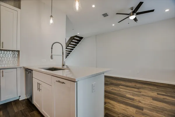 a kitchen with a sink a refrigerator and cabinets
