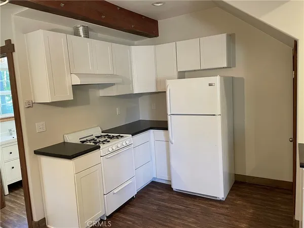 a white refrigerator freezer and a wooden floor