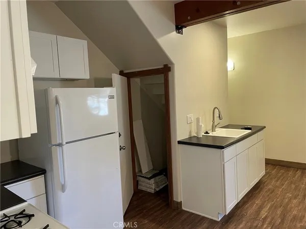 a kitchen with a sink a refrigerator and cabinets