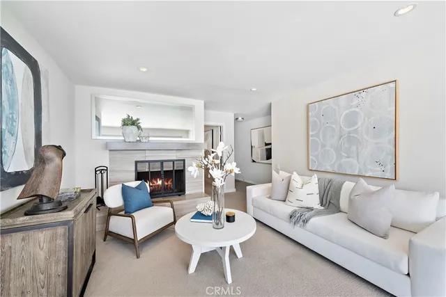 a living room with furniture a fireplace and a large window