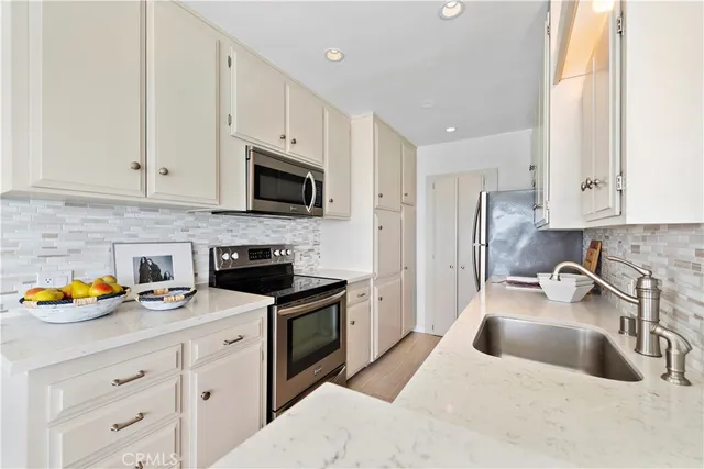 a kitchen with stainless steel appliances a stove a sink a stove and a microwave