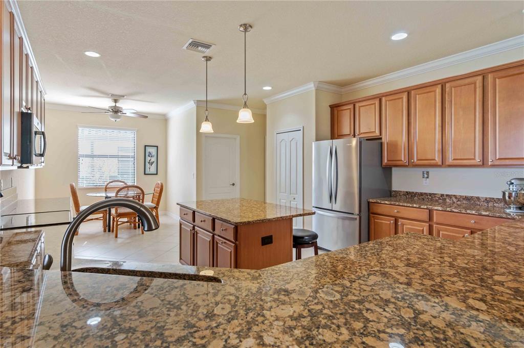 20370 Grazie Place Venice, FL 34293 - Photo 12 of 86 a kitchen with stainless steel appliances granite countertop a refrigerator a sink a stove and a wooden cabinets