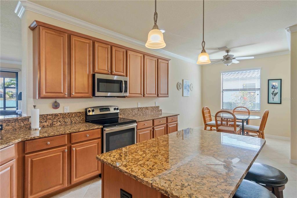 20370 Grazie Place Venice, FL 34293 - Photo 14 of 86 a kitchen with granite countertop a stove a sink a dining table and chairs