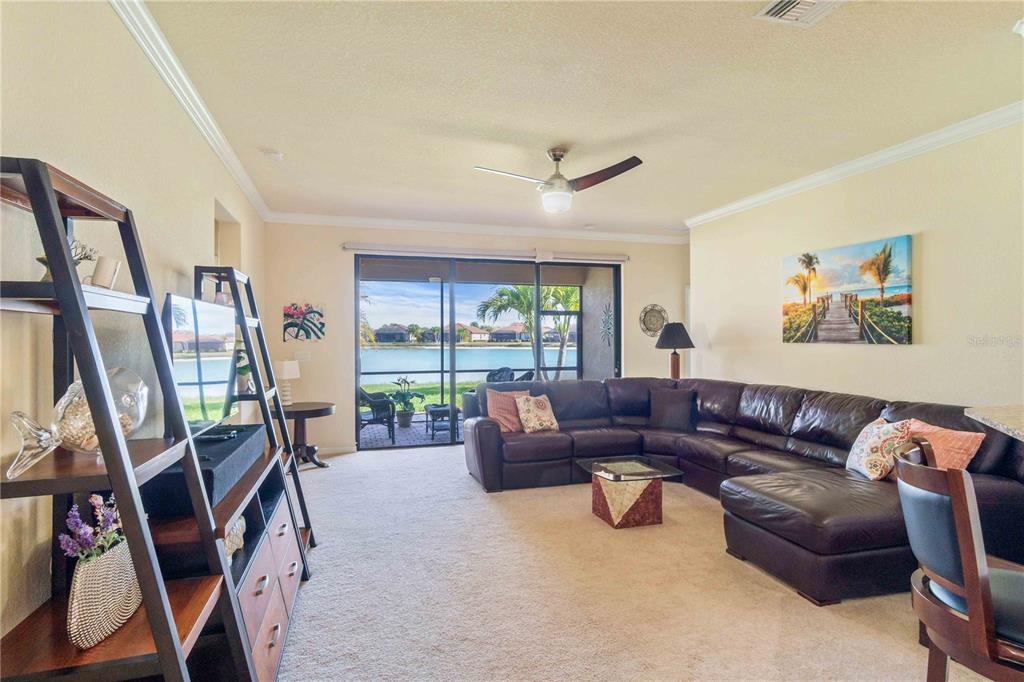 20370 Grazie Place Venice, FL 34293 - Photo 29 of 86 a living room with furniture a flat screen tv and a large window