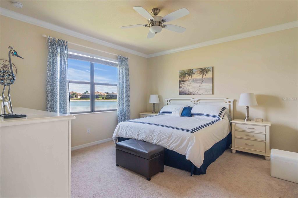 20370 Grazie Place Venice, FL 34293 - Photo 40 of 86 a bedroom with a bed lamp and a large window