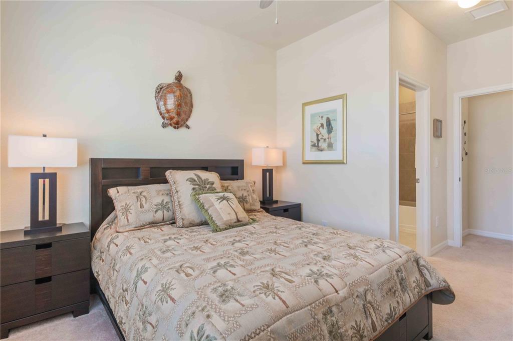20370 Grazie Place Venice, FL 34293 - Photo 64 of 86 a bedroom with a large bed and a lamp