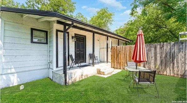 a backyard of a house with table and chairs