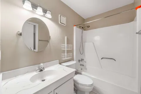 a bathroom with a sink a toilet and a mirror