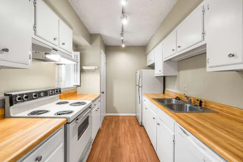 a kitchen with stainless steel appliances a stove a sink and a refrigerator