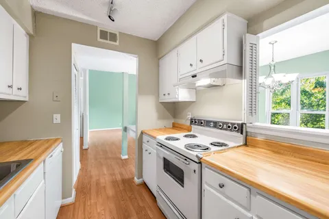 a kitchen with stainless steel appliances granite countertop a stove and a white cabinets
