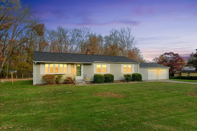 a view of a house with a yard and a garage