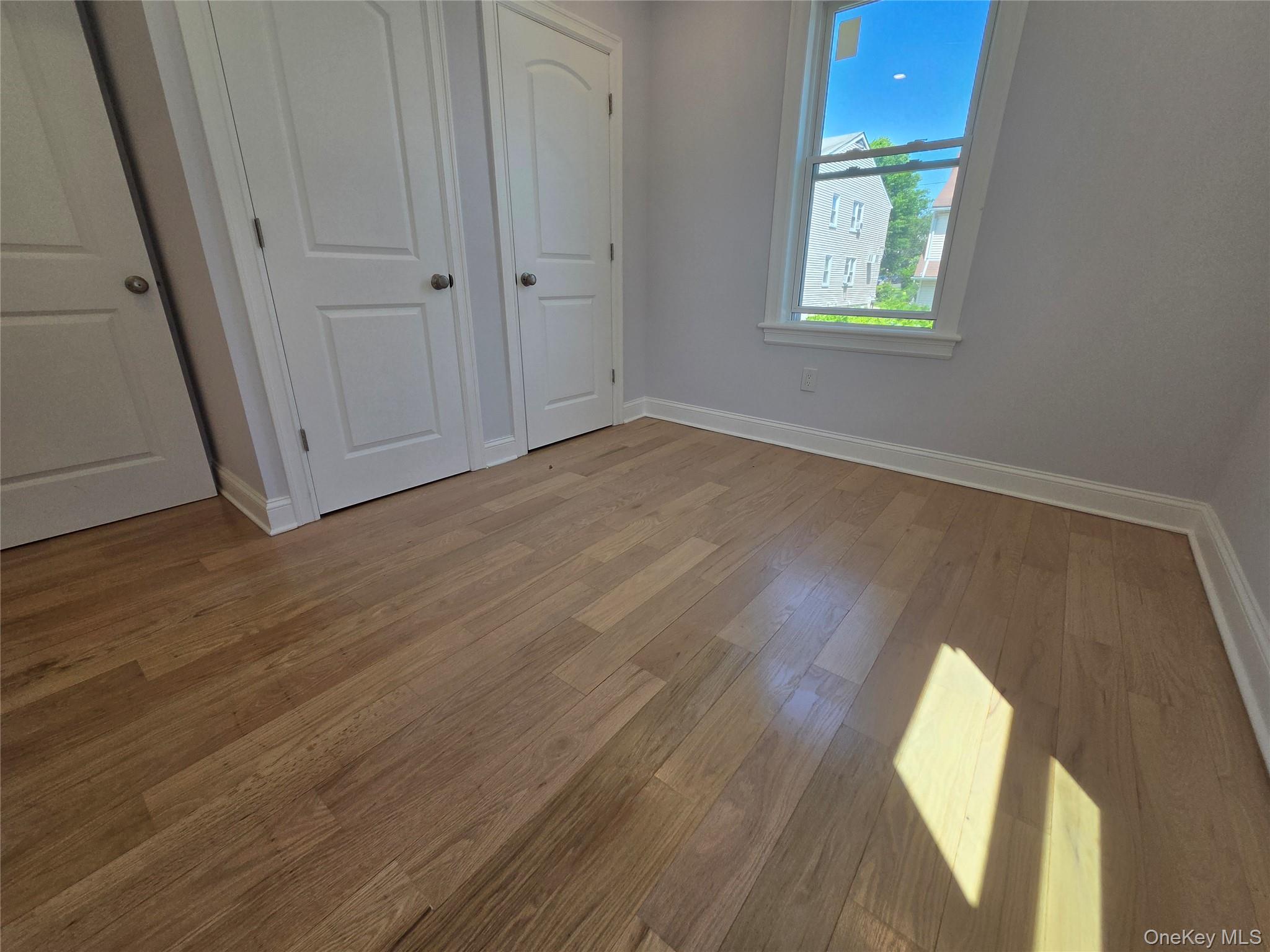 965 Main Street, Unit 2 New Rochelle, NY 10801 - Photo 9 of 12 Warm wood-finish flooring with crisp white baseboards