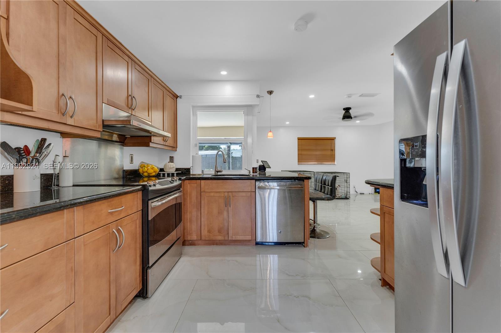6924 Northwest 8th Court Margate, FL 33063 - Photo 12 of 38 a kitchen with stainless steel appliances granite countertop a refrigerator sink and stove
