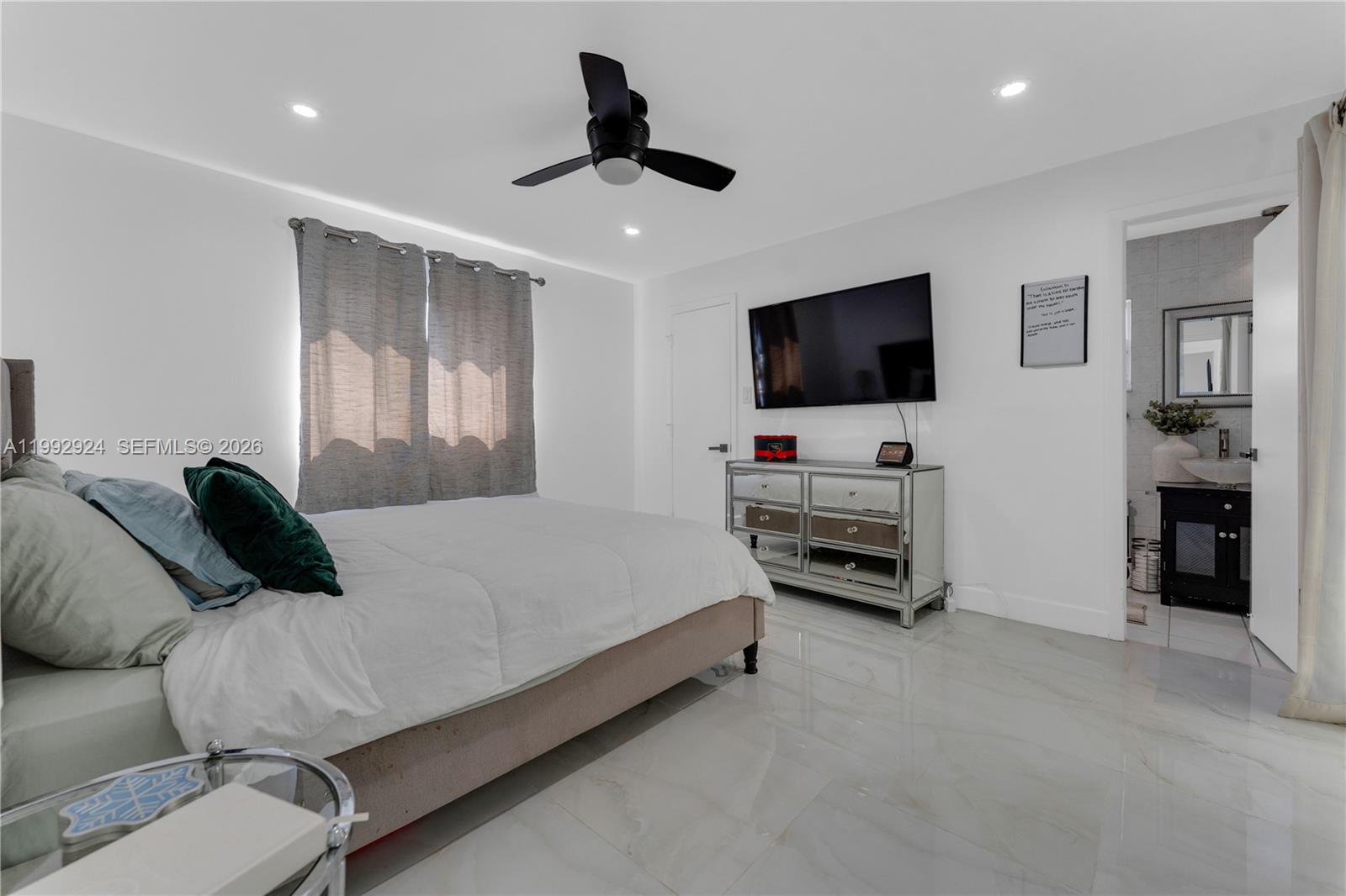 6924 Northwest 8th Court Margate, FL 33063 - Photo 20 of 38 a bedroom with a bed and a flat screen tv