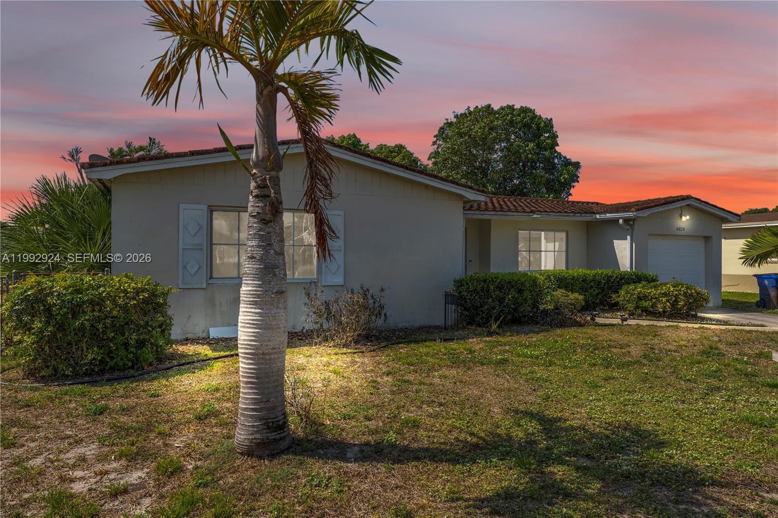 6924 Northwest 8th Court Margate, FL 33063 - Photo 2 of 38 a palm tree sitting in front of a house with a yard