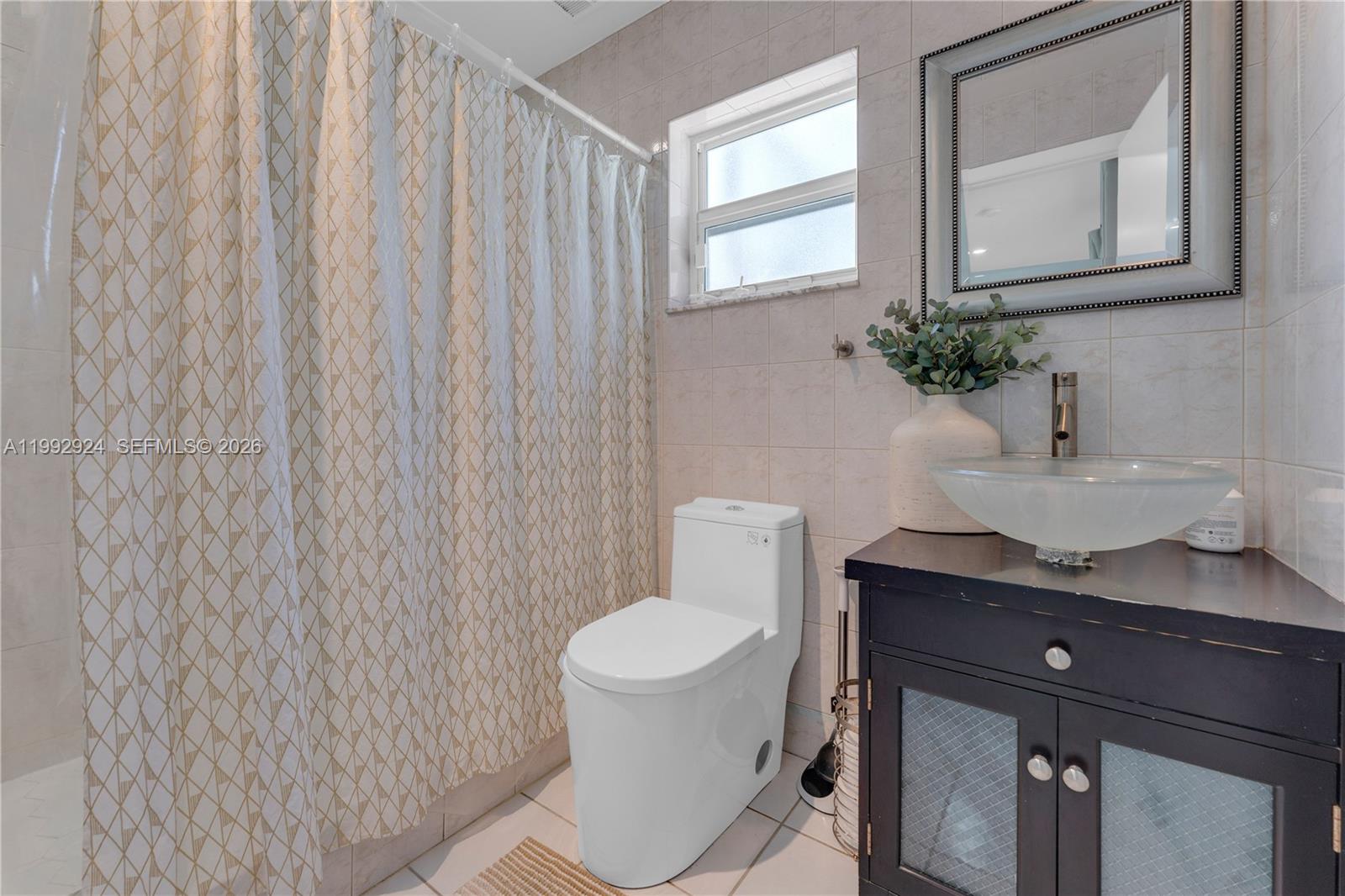 6924 Northwest 8th Court Margate, FL 33063 - Photo 22 of 38 a bathroom with a toilet a sink and a window
