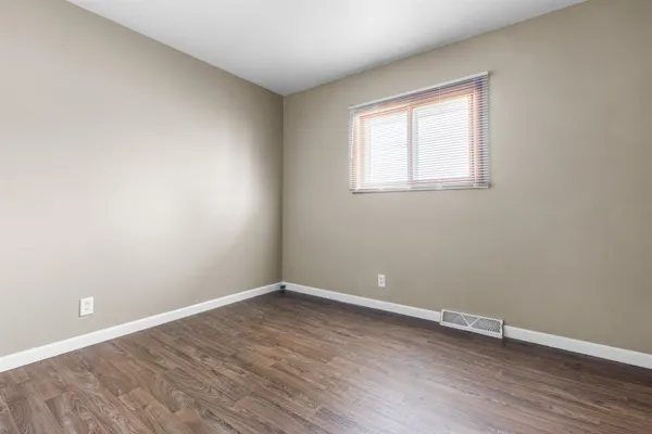 a view of a room with wooden floor and window