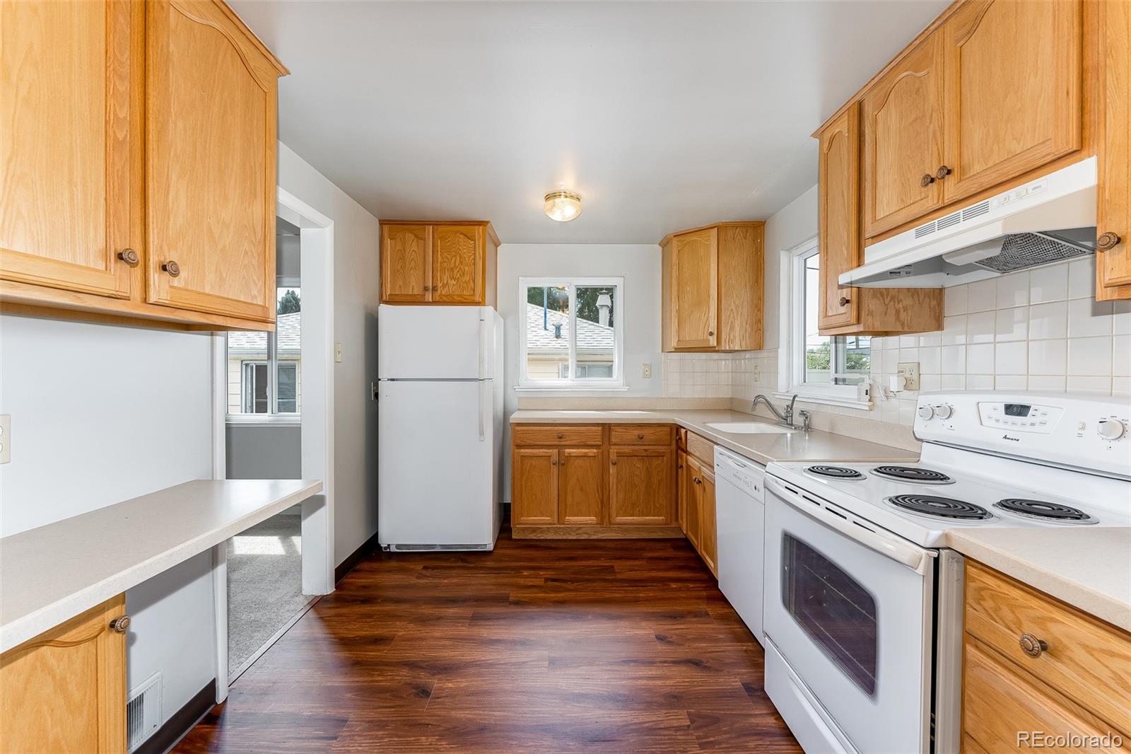 2817 Gray Street Wheat Ridge, CO 80214 - Photo 8 of 18 a kitchen with stainless steel appliances granite countertop a refrigerator a stove a sink and a microwave