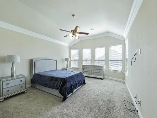 a spacious bedroom with a bed a chandelier and large window