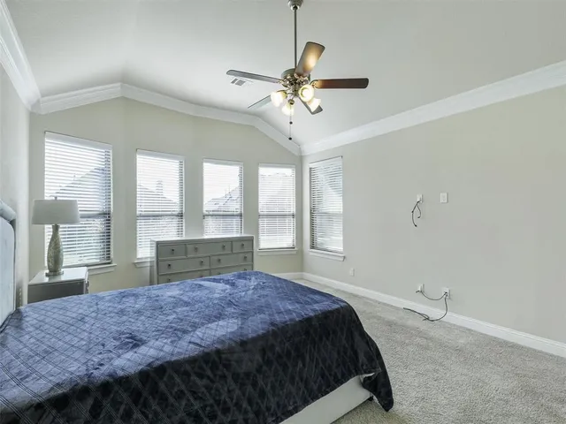 a spacious bedroom with a large bed and a chandelier