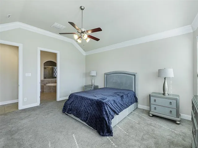 a spacious bedroom with a bed and a chandelier