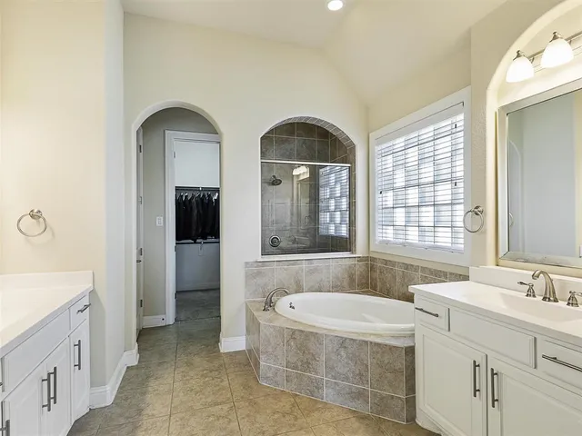 a spacious bathroom with sinks mirror and a bathtub
