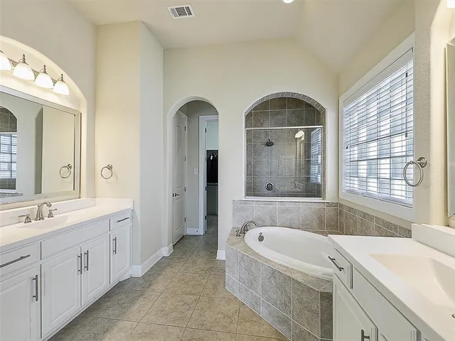 a bathroom with a granite countertop sink mirror bathtub and shower
