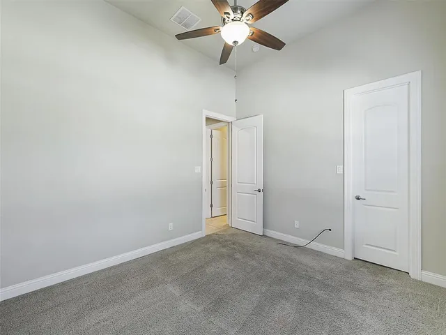 an empty room with closet and fan