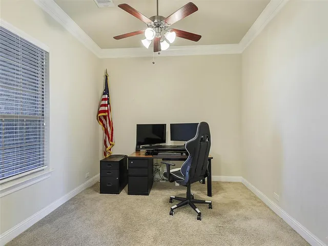 a view of a workspace with furniture and a window
