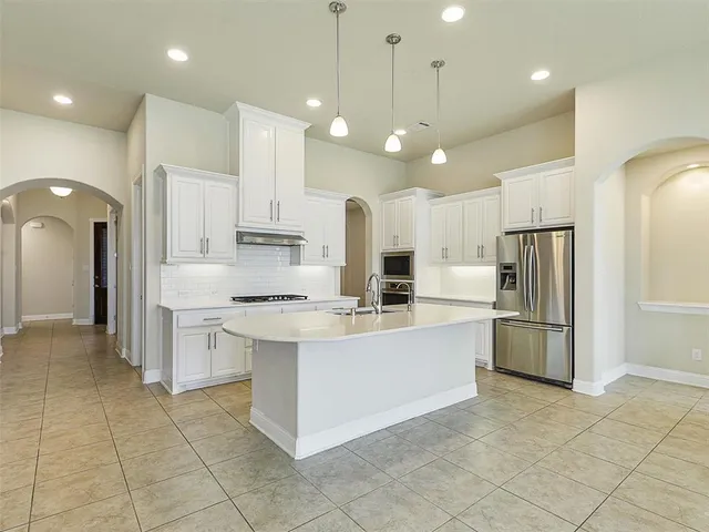 a large kitchen with cabinets and stainless steel appliances