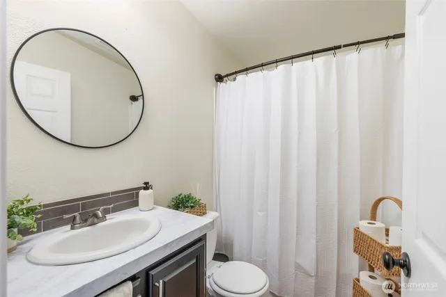 a bathroom with a sink toilet and a mirror