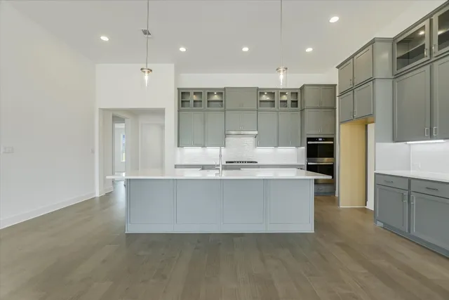 a large kitchen with kitchen island a sink stainless steel appliances and cabinets