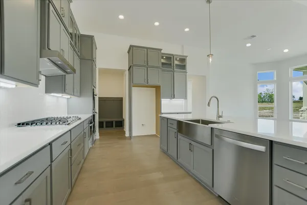 a large kitchen with stainless steel appliances granite countertop a sink and a stove