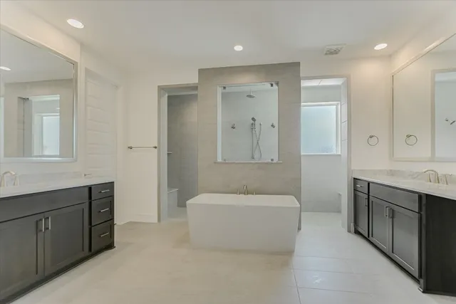 a bathroom with a tub a sink shower and mirror