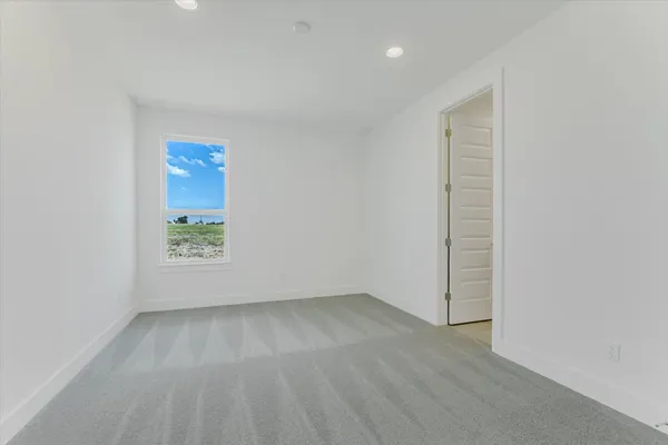 an empty room with wooden floor and window