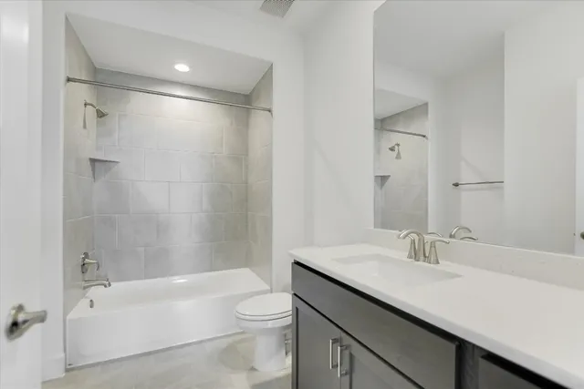 a bathroom with a granite countertop sink a toilet and shower