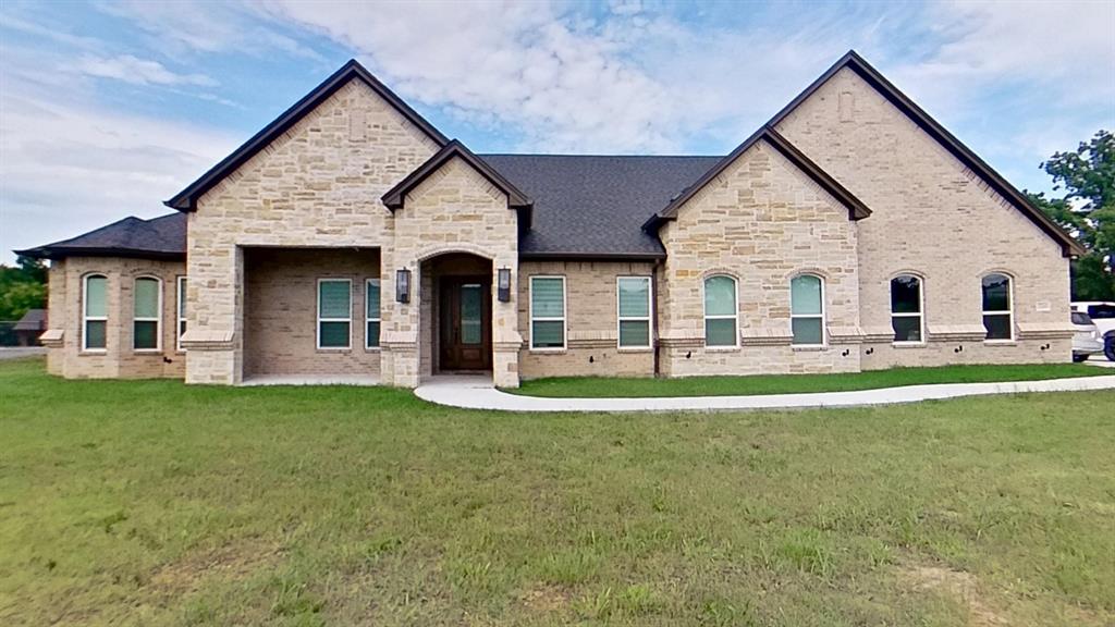 3248 North Cardinal Road Azle, TX 76020 - Photo 4 of 29 Stone and brick facade featuring a covered entry, arched doorway with glass paneling, and a dark shingle roof