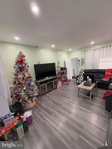 a living room with furniture a flat screen tv and a floor to ceiling window