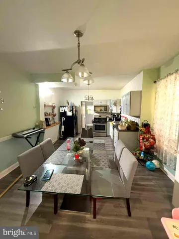 a room with lots of furniture and view of kitchen